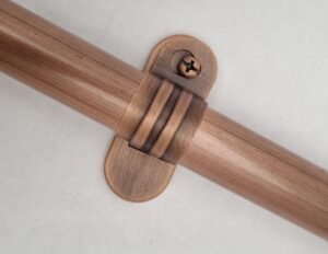 Copper conduit saddle for securing surface-mounted electrical conduit.
